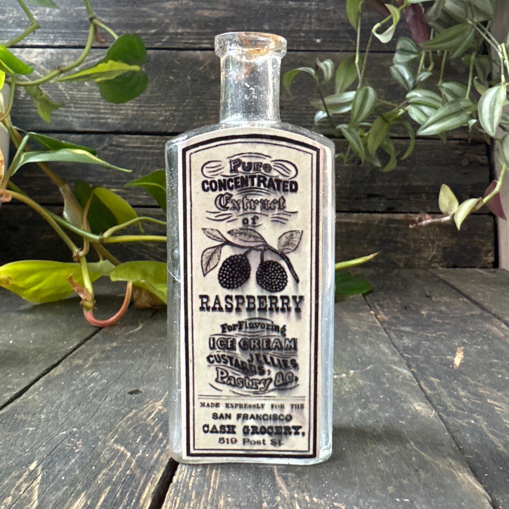 Antique glass bottle with extract of raspberry label