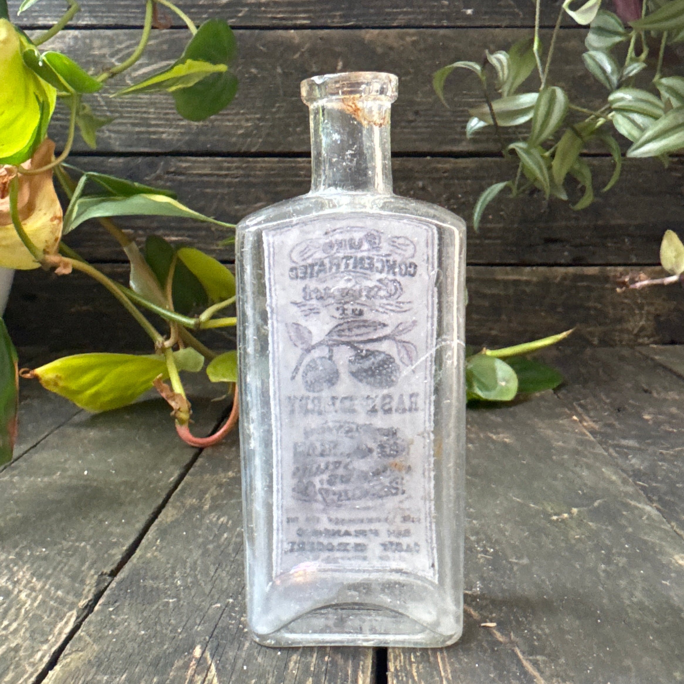 Antique glass bottle with extract of raspberry label